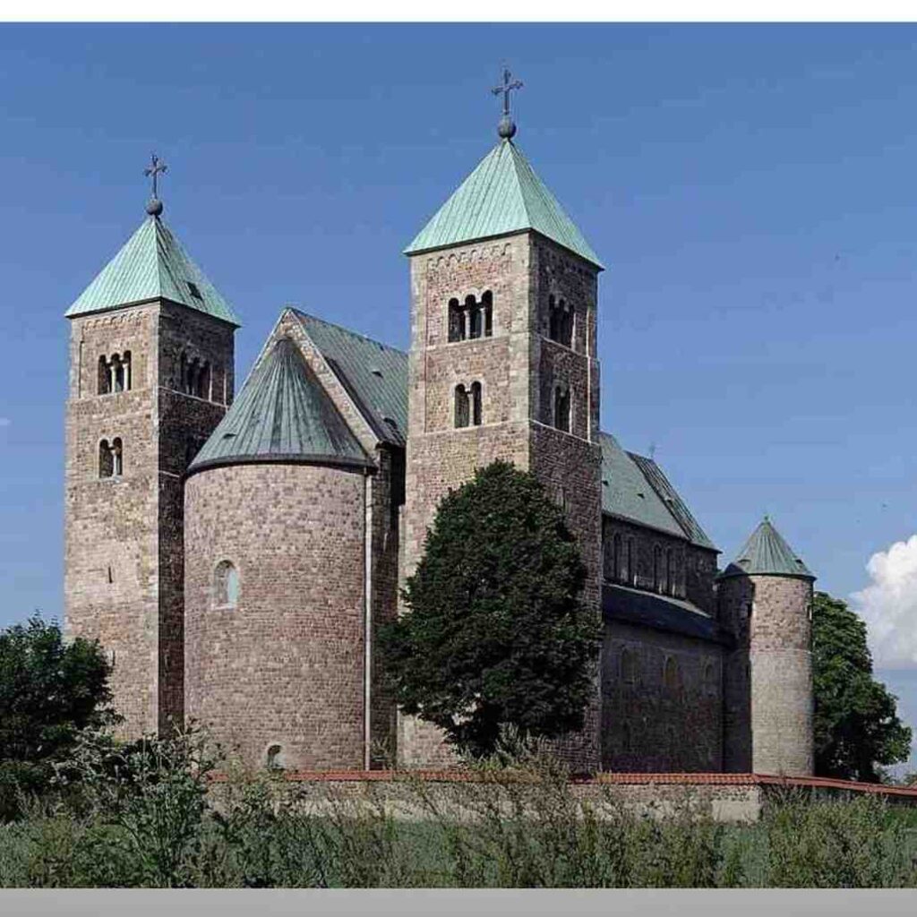 Romanesque stone church featuring rounded arches and thick, fortress-like walls.