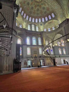 The Blue Mosque (Sultan Ahmed Mosque) in Istanbul showcasing its cascading domes, six minarets, and classical Ottoman architecture during golden hour.