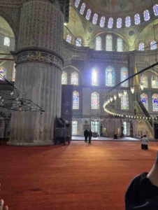 The Blue Mosque (Sultan Ahmed Mosque) in Istanbul showcasing its cascading domes, six minarets, and classical Ottoman architecture during golden hour.